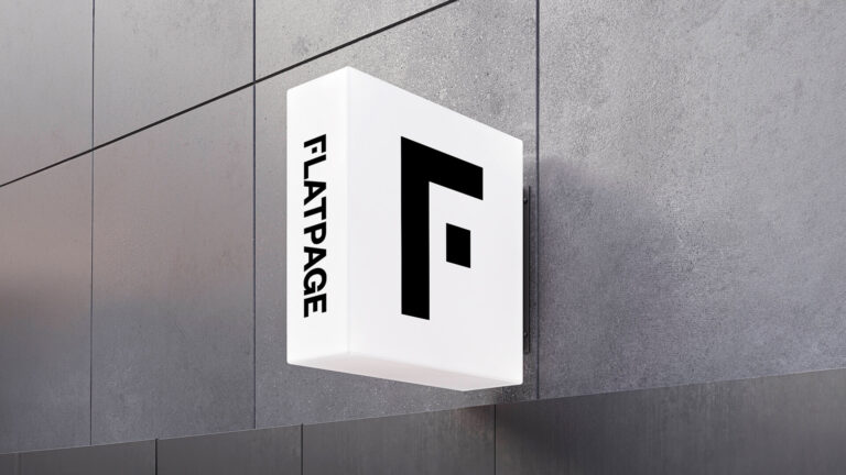 Flatpage sign hanging from a gray wall. Flatpage is an editorial agency and publishing house supporting nonfiction authors and organizations.