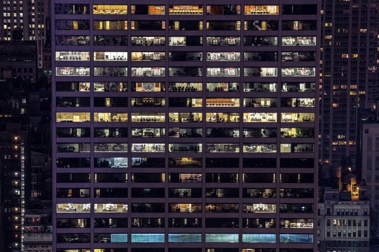 The exterior of a high-rise building in a city, perhaps one managing editorial workflows in a merger.