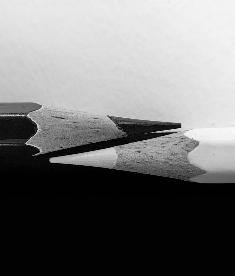 Two pencils, one black, one white. The black represents nonfiction authors published at Flatpage, whereas the white represents our expertise in editorial services for nonfiction authors.