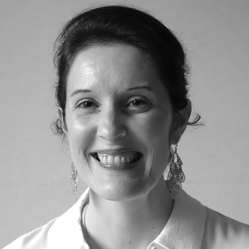 A copyeditor with dark hair and a wide smile.