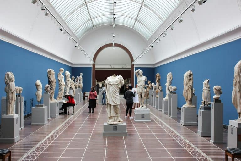 A museum gallery full of works and visitors