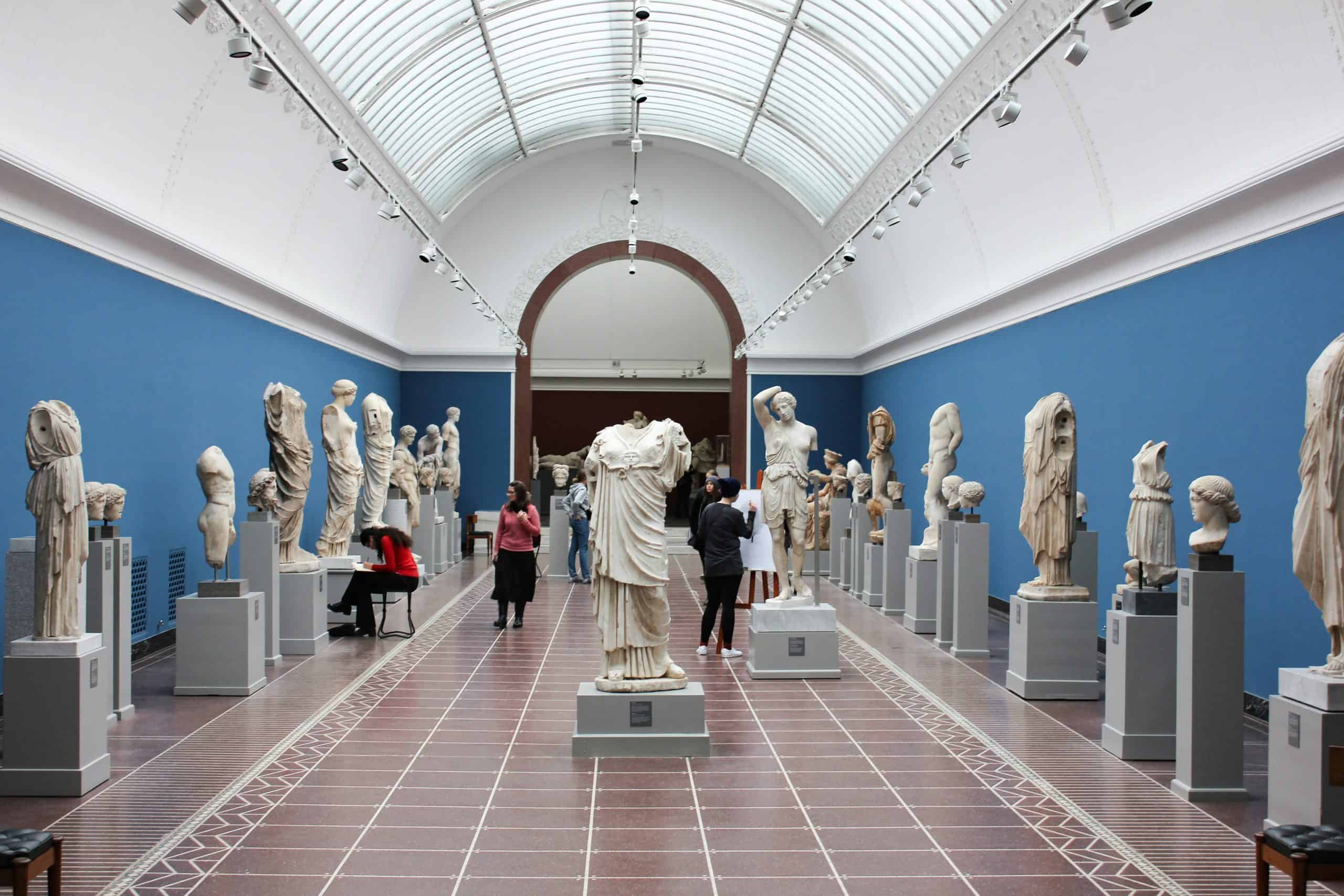 A museum gallery full of works and visitors