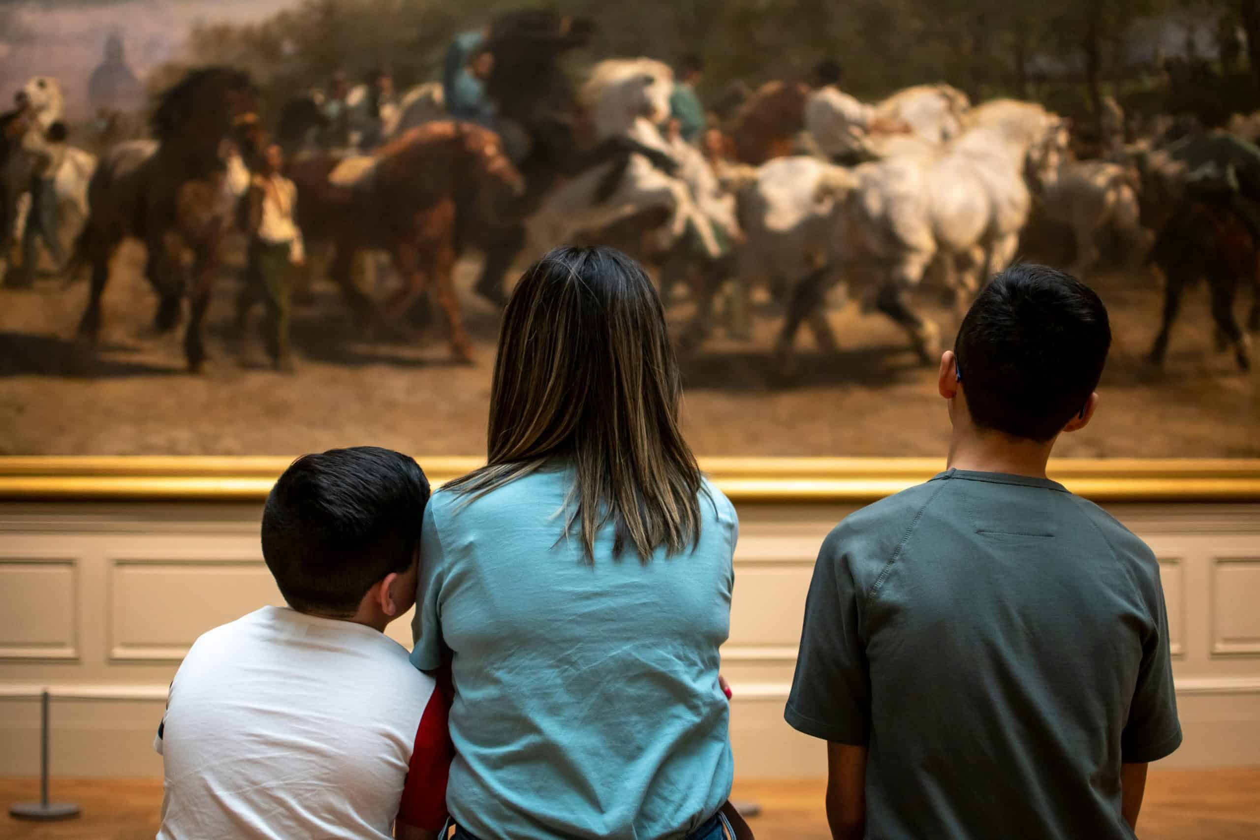 A group of visitors looking at a work of art in a museum.